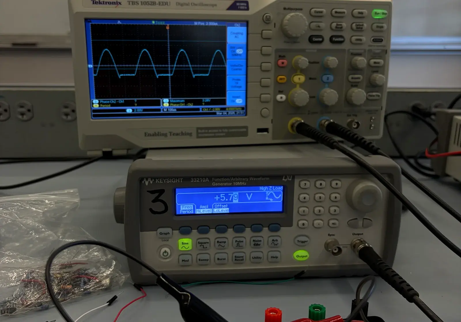 Oscilloscope and function generator measuring a circuit on a lab bench