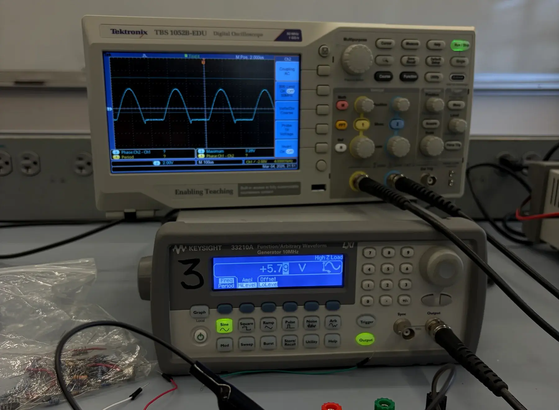 Oscilloscope and function generator on an electronics lab bench